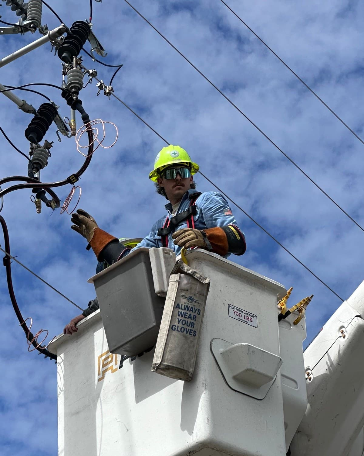 Chase McKinnon, founder of McKinnon Solutions, doing line work from a bucket truck.